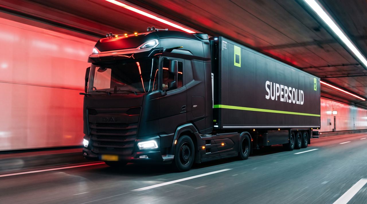 A SuperSolid DAF XG tractor pulling a branded refrigerated trailer through a red-lit tunnel at speed